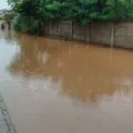 Chuva faz córrego transbordar e deixa rua intransitável em Presidente Olegário